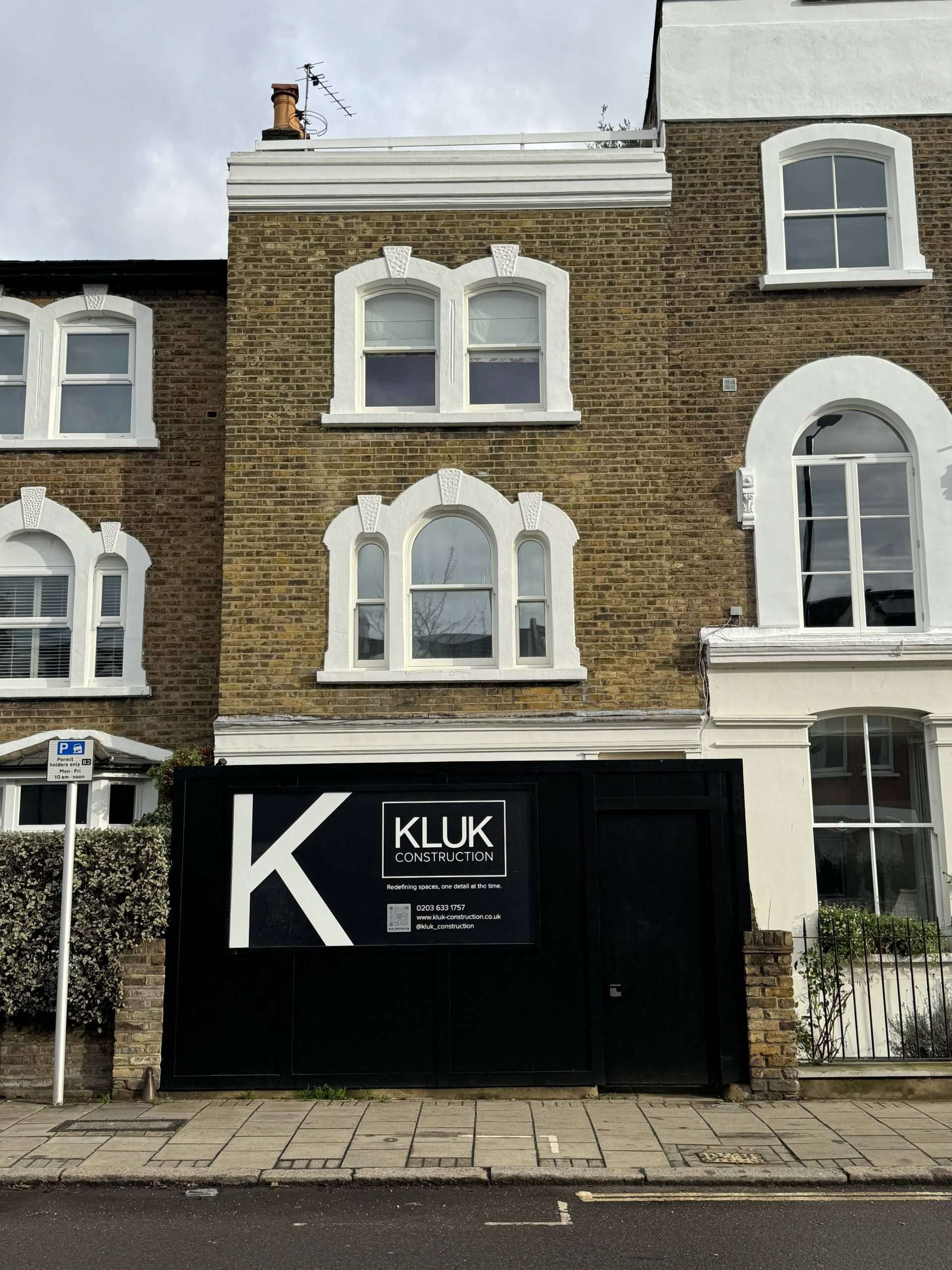 Kluk Construction signature black hoarding displayed outside a residential renovation and extension project.