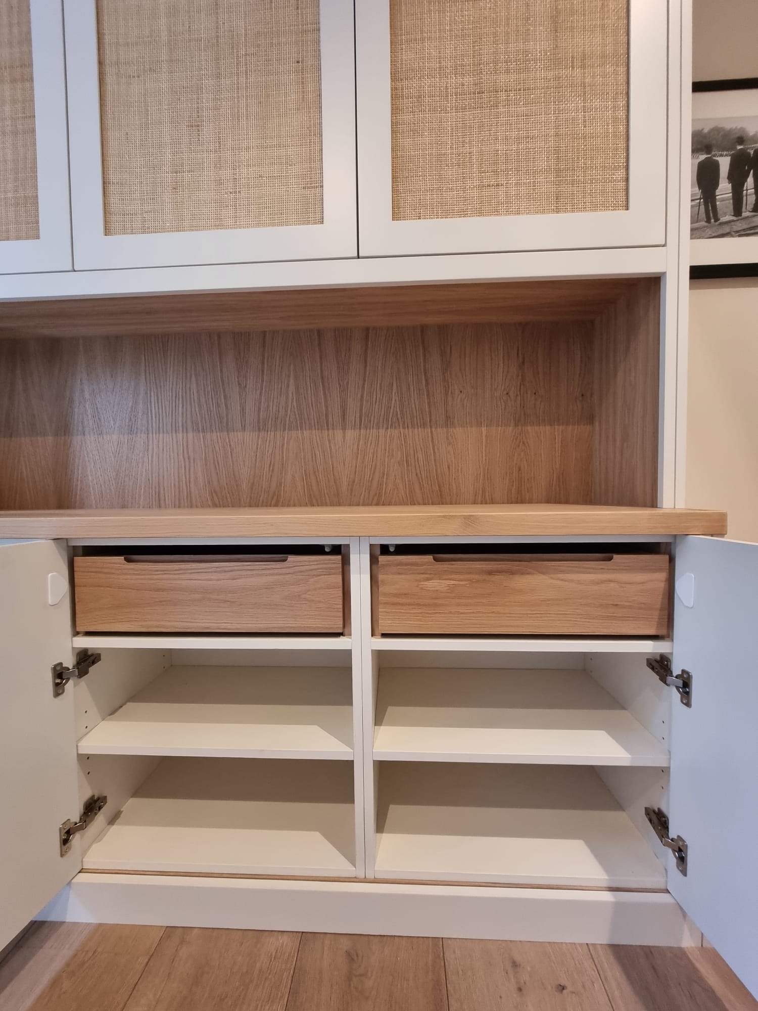 Interior of bespoke fitted storage unit with oak drawers and rattan cabinet doors