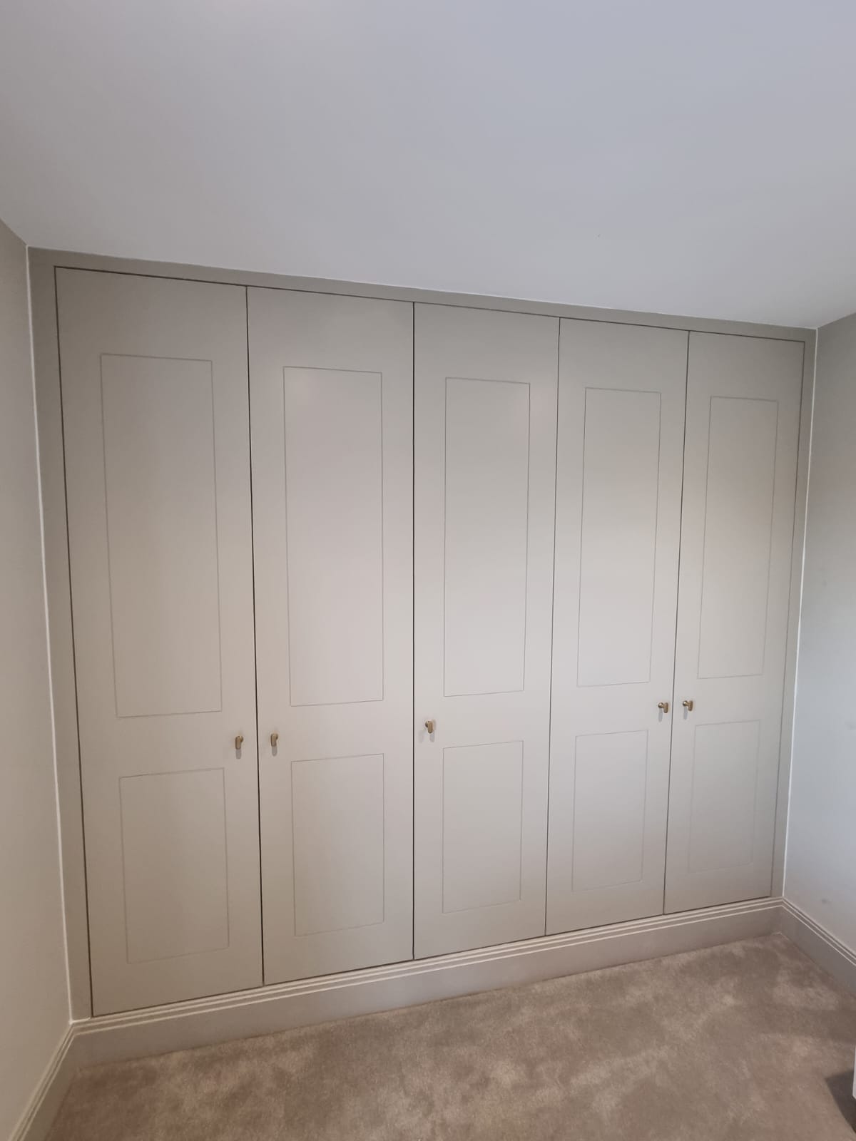 Bespoke fitted wardrobes with panelled doors in a London bedroom