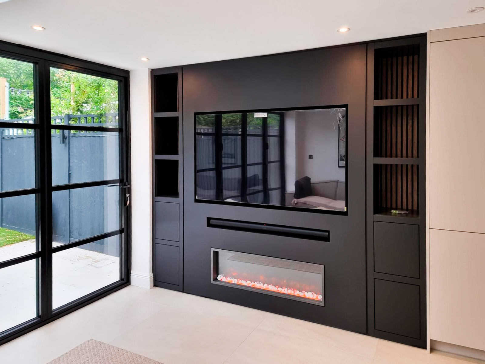 Bespoke built-in TV media unit with shelving and integrated electric fireplace